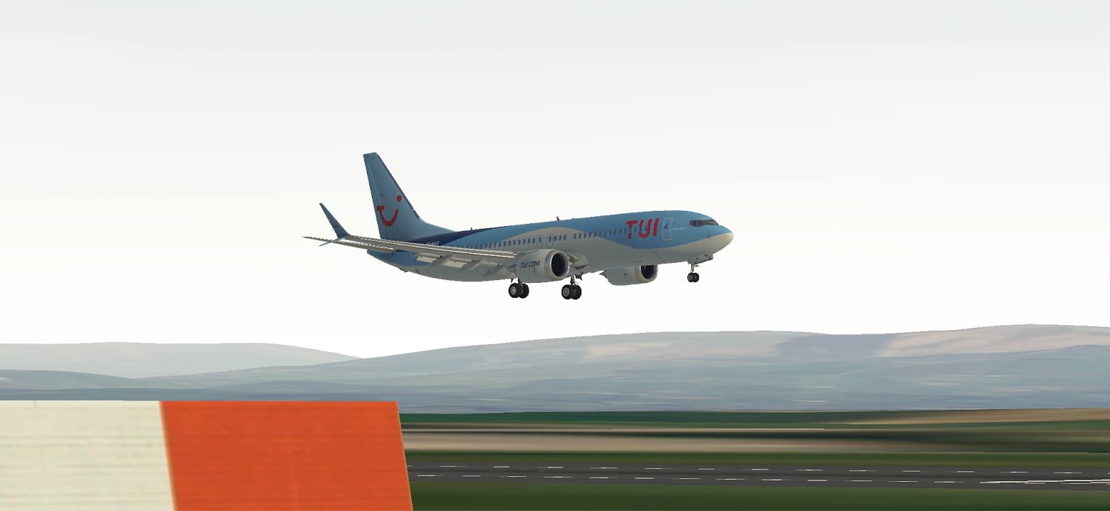A TUI Boeing 737 MAX about to touch down over green hills